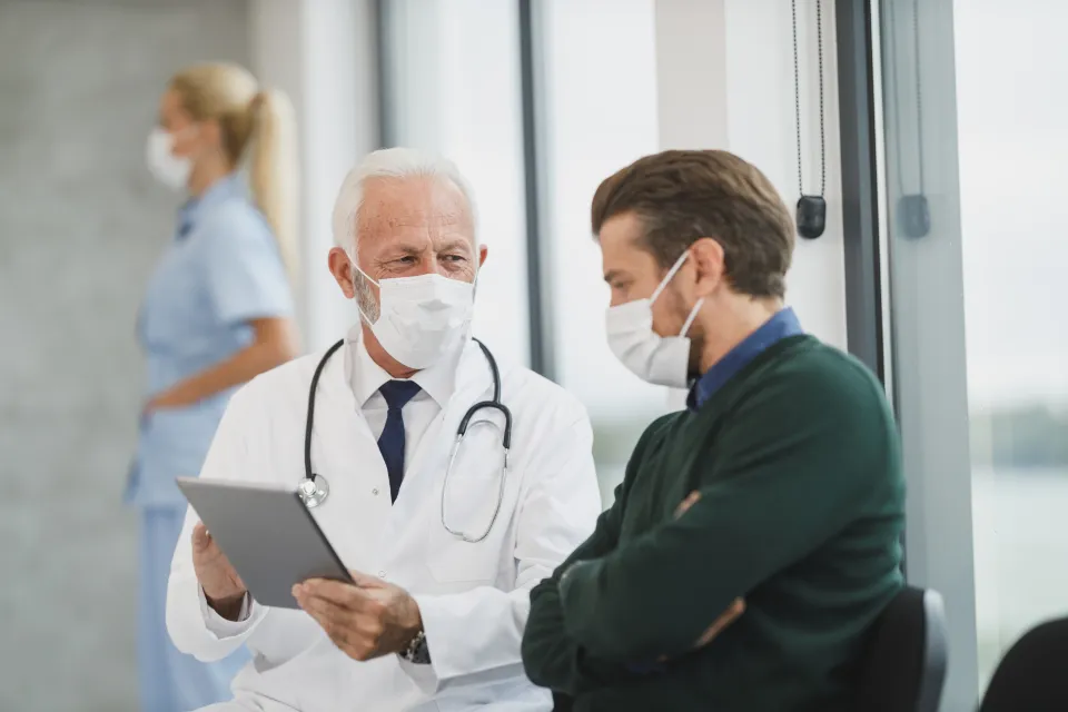 Doctor reviewing a tablet with a patient in a clinic