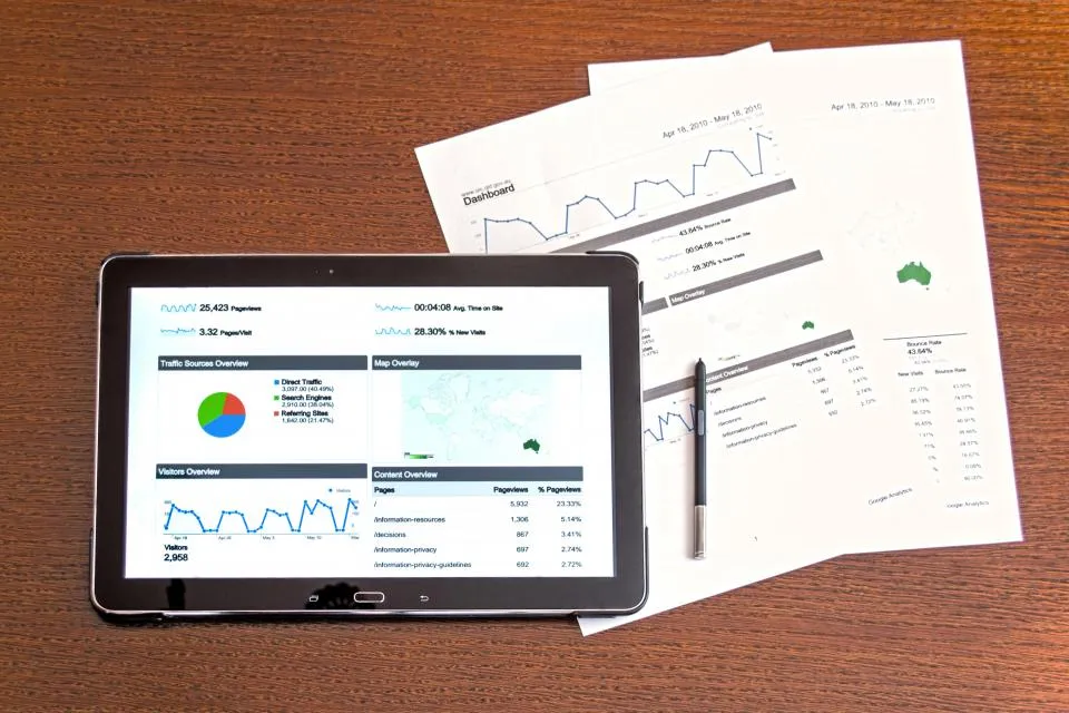 Tablet showing a dashboard beside printed reports