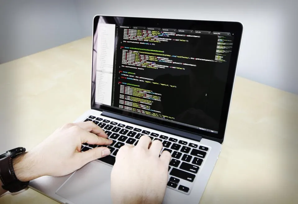 Developer typing code on a laptop